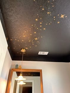 the ceiling is decorated with gold stars on black and white walls, along with a mirror