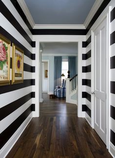 a hallway with black and white stripes painted on the walls, wood flooring and wooden floors