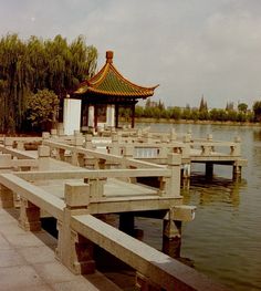 an empty dock in front of a body of water with a gazebo on the other side