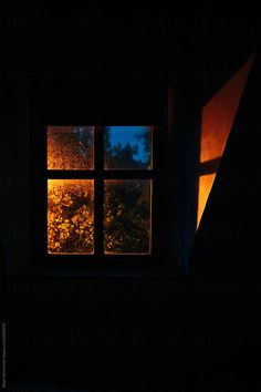 an open window in a dark room with the light coming from it's windowsill