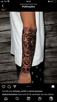 a man's arm with a tiger tattoo on it and roses in the middle