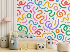 a colorful wallpaper in a child's room with toys on the wooden floor