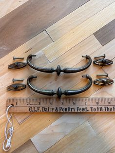 an old fashioned door handle is next to a tape measure ruler on the wooden floor