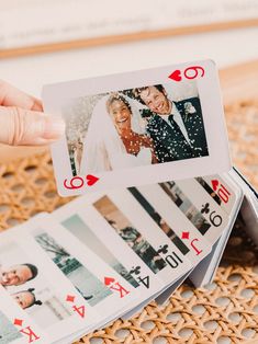 two playing cards with pictures on them being held up by someone's hand while they are sitting on a table