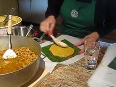 a person in an apron stirring food into a pot