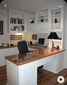 a home office with white cabinets and wood flooring