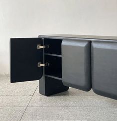 a black cabinet with two doors open on the floor