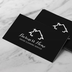 two business cards sitting on top of a marble surface with the logo for house cleaning service