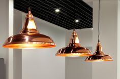 three copper colored lights hanging from the ceiling