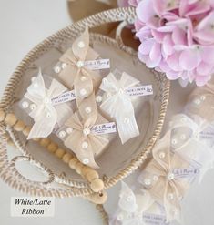 some little bows are sitting on a plate next to flowers and beaded bracelets