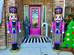 two nutcrackers are standing in front of a pink door