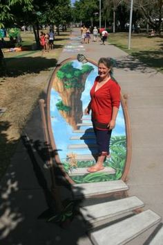 a woman standing in front of a painted surfboard