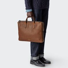 The Slim Traveler Brief. An interior padded pockets fits a 15" laptop with ease, while additional slip pockets hold your phone and other necessities. Pen pockets, a leather card pocket, and exterior pockets add thoughtful design touches. From home to work and back again, the Slim Traveler Brief can pack it all in—while still maintaining a slim and sleek profile. | Shinola Men's | The Slim Traveler Brief | Brown Leather Lifestyle Clothing, Laptop Pocket, Small Leather Goods, Tech Accessories, Corporate Gifts, Watch Strap, Pet Collars, Brown Leather, Leather Bag