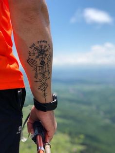 a man with a compass tattoo on his arm