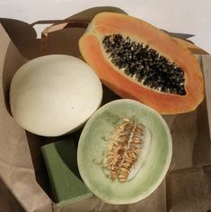 a couple of papayas sitting on top of a brown paper bag