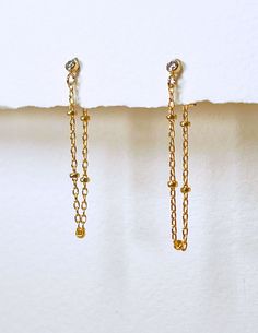 Sometimes, you find yourself in the mood to make a statement, but you also don't want to be obvious or loud about it.  When that mood strikes you, these earrings are just what you need.   Each earring features a beautiful 2 mm bezel set cubic zirconia studs with a satellite chain with 1.8 mm balls gently draping down and around your earlobe to create a fluid hoop. When ordering, please indicate your preference for finish and length.  While the photos depict the earrings with white pearls, please indicate if you prefer to have pink pearls. ✶ P R O D U C T ✶ D E T A I L S ✶ + 2mm Gold-Filled Bezel Set CZ Stud Earrings  + 2.5 mm to 3 mm Freshwater Pearls + 1.8 mm Ball Satellite Chain Loops * O R D E R I N G * I N S T R U C T I O N S * + Select metal finish: Yellow Gold, Rose Gold or Sterling Yellow Gold Threader Earrings With Delicate Chain, Delicate Chain Yellow Gold Linear Earrings, Yellow Gold Threader Earrings With Adjustable Chain, Gold Threader Earrings With Adjustable Chain, Long Drop, Gold-plated Linear Dangle Earrings With Adjustable Chain, Chain Threader Earrings, Gold Lariat Necklace, Chain Loop, Cz Stud Earrings