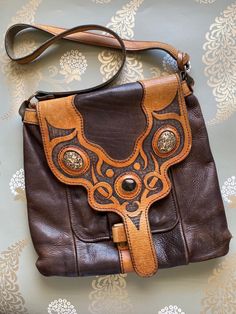 This is a great find is a 1970's vintage leather bag and features a tooled flap closure, center black onyx stone and side jasper stones all encased in tooled leather. It's a sturdy bag that is in great shape with a wonderful patina, or condition it up and make it look like new! Luxury Hand-tooled Brown Satchel, Luxury Hand Tooled Brown Satchel, Luxury Brown Hand-tooled Satchel, Luxury Brown Hand Tooled Satchel, Bohemian Brown Bags With Concho, Bohemian Brown Bags With Leather Backing, Brown Leather Bohemian Satchel, Brown Bohemian Leather Satchel, Bohemian Brown Leather Satchel