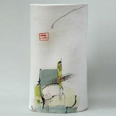 a white vase with an abstract painting on it