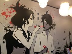 two people are brushing their teeth in front of a wall mural with blood splatters