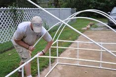 a man climbing up the side of a white metal stair rail next to a car