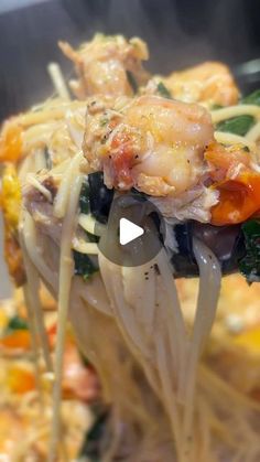 a spoon full of noodles with shrimp and vegetables