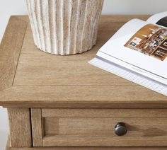 a magazine sitting on top of a wooden table next to a cup