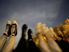 three people with their feet up in the air