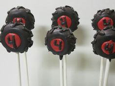 three chocolate cake pops with red and black frosting on them are arranged in a row