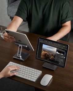 two people sitting at a table with an ipad and a tablet on their lap top