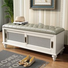 a white bench sitting on top of a hard wood floor next to a rug and shoes