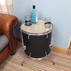 a table with two glasses on it next to a leather chair and a brown couch