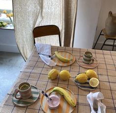 a table topped with plates and cups filled with food next to a banana on top of a plate