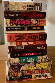 a stack of books sitting on top of a wooden table