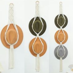 three hats hanging on the wall with tassels attached to each one and two different colors