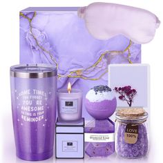 a purple gift set with candles, candle holder and other items in front of it