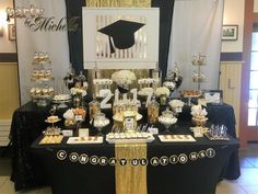 a black and gold graduation party table with desserts on it's tablescape