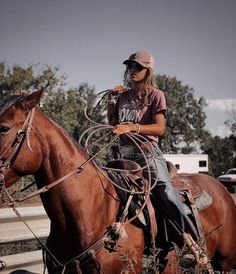 a woman riding on the back of a brown horse