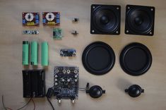 the electronic components are laid out neatly on the wooden surface, including speakers and other electronics