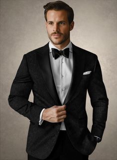 a man in a tuxedo is posing for the camera with his hands on his hips