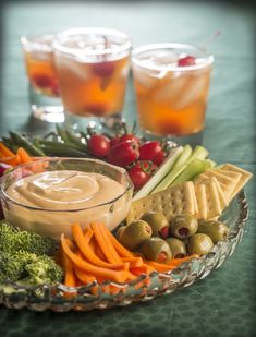 a glass bowl filled with assorted veggies and dip