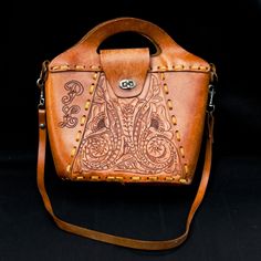 Vintage 1970s Tooled Leather Shoulder Bag Designed with the initials "P. L." Measurements: Height: 11.5 in. (w/ Handle) Length: 11 in. Depth 4 in. Vintage Hand Tooled Top Handle Shoulder Bag, Vintage Engraved Leather Shoulder Bag, Vintage Brown Hand Tooled Rectangular Shoulder Bag, Hand Tooled Vintage Brown Bohemian Shoulder Bag, Retro Vintage Brown Hand Tooled Shoulder Bag, Vintage Tools, Leather Tooling, Leather Shoulder Bag, Purses And Handbags