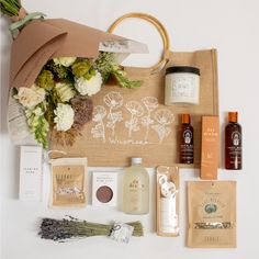 the contents of a bag laid out on a white surface with flowers and other items