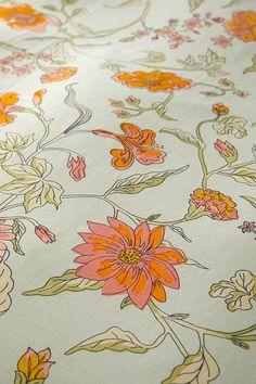 an orange and yellow floral print on white fabric