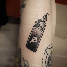 a person with a tattoo on their leg has a lighter in the shape of an arrow