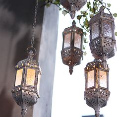 three hanging lanterns are lit up in the air