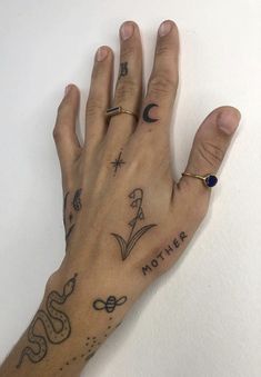 a person's hand with tattoos on it