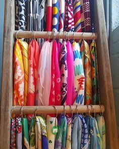 an old wooden rack holding many different colored umbrellas