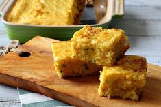 three pieces of cornbread sitting on top of a wooden cutting board