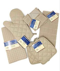 five oven mitts and four oven mitts with tags on them, all in beige