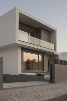 an exterior view of a modern house with glass balconies